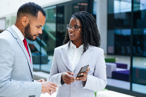 A business man and a business woman talking about how to address corporate culture dysfunction.